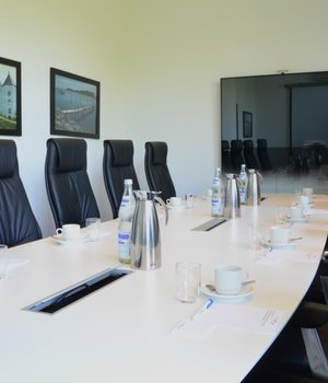 Conference room with long table and TV Hotel des Nordens